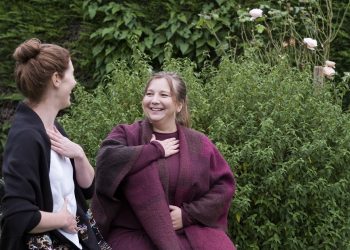 A woman and a therapist talking in a garden.