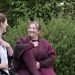 A woman and a therapist talking in a garden.