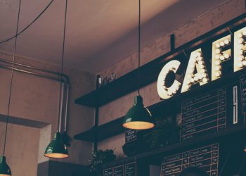 Photography of cafe with LED signage and pendant lamps and menu boards
