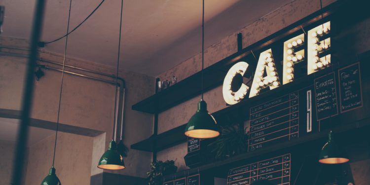 Photography of cafe with LED signage and pendant lamps and menu boards