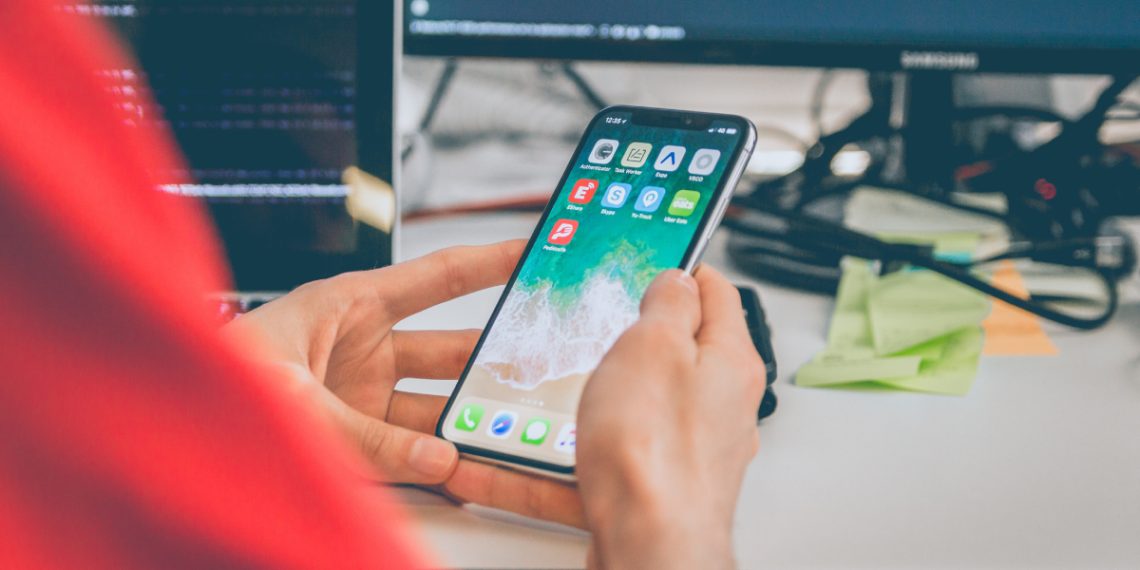 A person in red is using silver iphone
