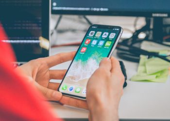 A person in red is using silver iphone
