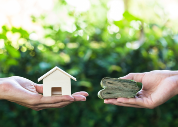 Navigating the Reward and Risk Landscape of Home Loan Refinancing Banner Image - Hand holding home model change to money with green nature as background. Conceptual changing residence into cash