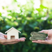 Navigating the Reward and Risk Landscape of Home Loan Refinancing Banner Image - Hand holding home model change to money with green nature as background. Conceptual changing residence into cash