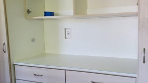 Wide view of closet with a power outlet.