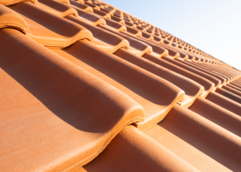 The Impact of Australia's Climate on Optimal Roofing Choices Banner Image - Overlapping rows of yellow ceramic roofing tiles covering residential building roof
