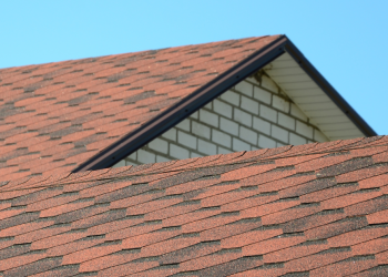 Top Benefits of Investing in a New Roof Banner Image - The roof is covered with bituminous shingles of brown color. Quality Roofing