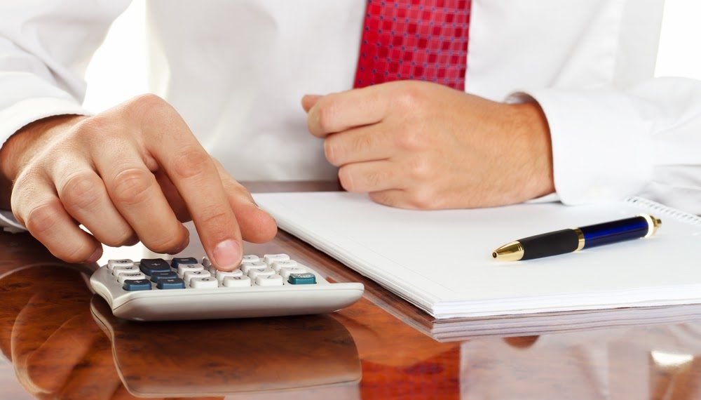 businessman with a calculator. calculation of costs, revenue, balance sheet