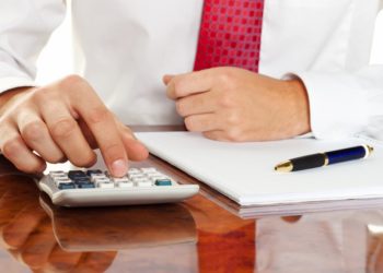 businessman with a calculator. calculation of costs, revenue, balance sheet