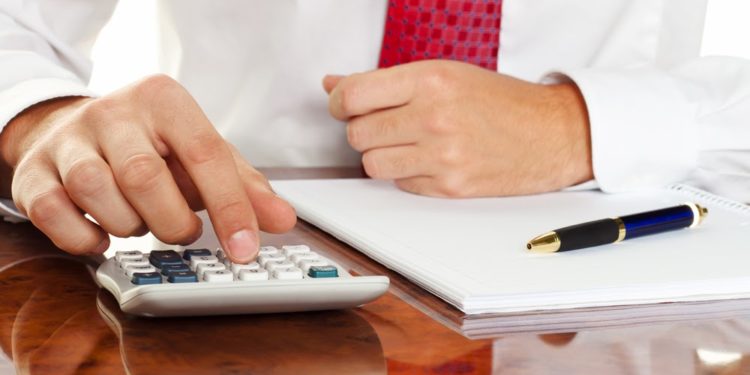 businessman with a calculator. calculation of costs, revenue, balance sheet