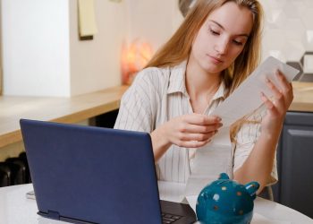Woman checks sales receipt after shopping. Returning goods, calculating costs, planning own budget.