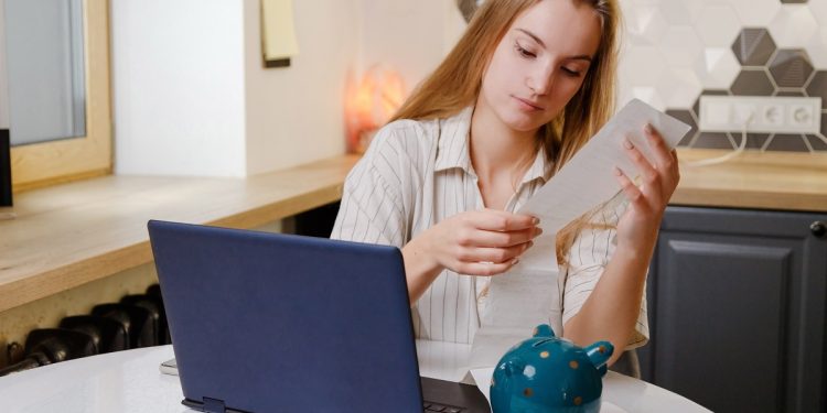 Woman checks sales receipt after shopping. Returning goods, calculating costs, planning own budget.