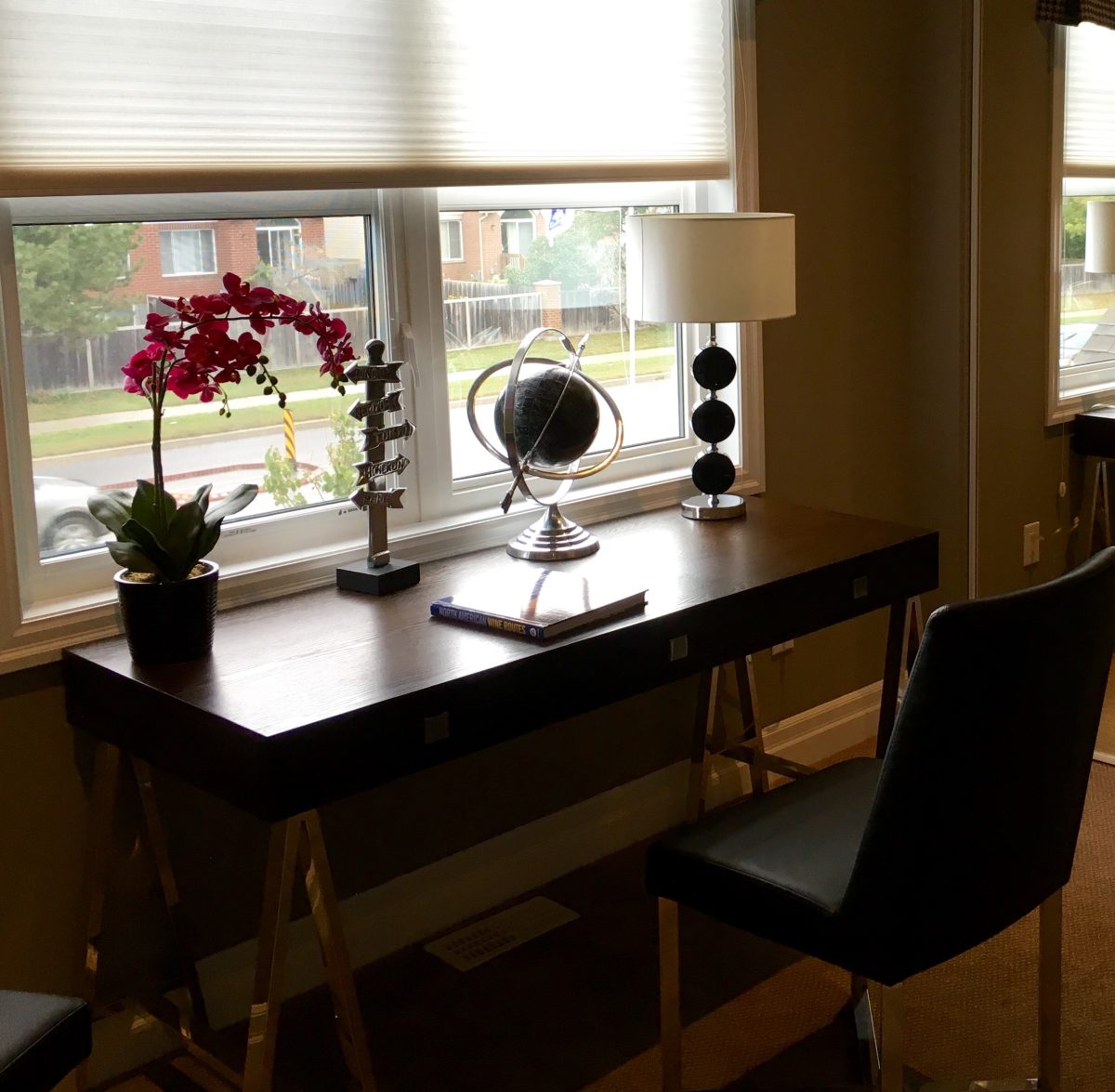 clean desk in front of a window shaded by roll shade