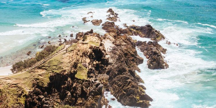 The iconic and famous Byron Bay lighthouse and rocky seascape on a hot autumn day in Byron Bay, New South Wales, Australia.