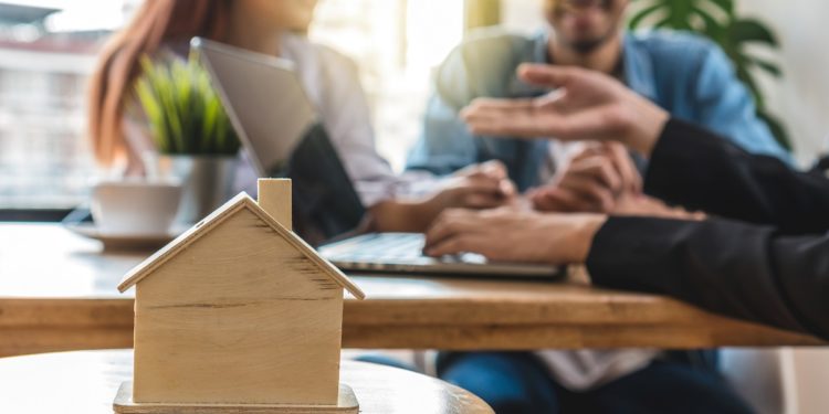 Closeup house model over the Sale representative offer the house