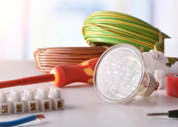 Composition with electrical material on a table and a window in the background. Horizontal composition. Front view.