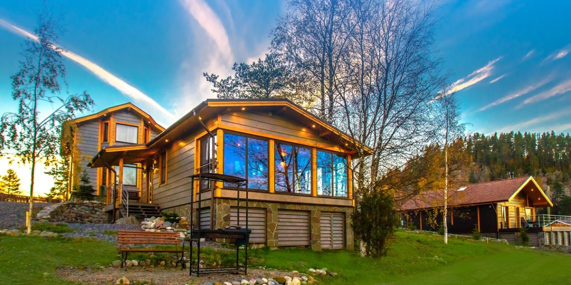 Cottage on the slope. Cottage village. House with large windows. The construction of the mysterious houses. Infrastructure. Living in the country. Wooden house.