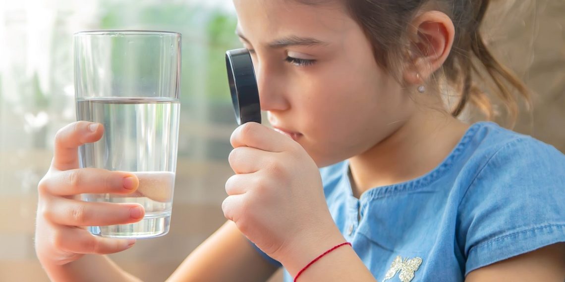 girl looking at glass of water