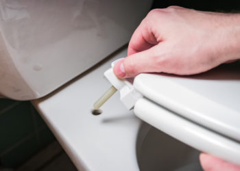 hand installing toilet seat