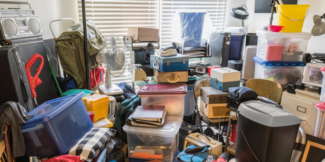 Hoarder room packed with boxes, electronics, business equipment, household objects and miscellaneous junk.
