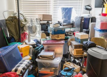 Hoarder room packed with boxes, electronics, business equipment, household objects and miscellaneous junk.