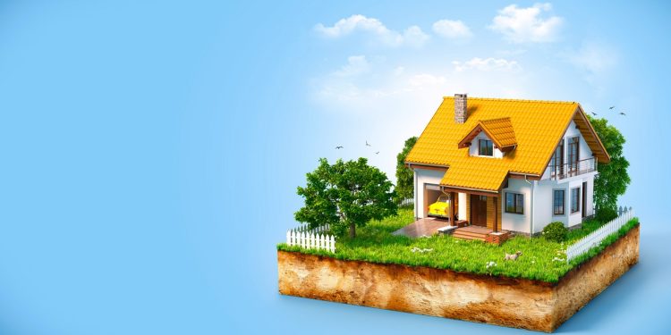 White house on a piece of earth with garden and trees.