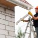 man fixing gutters on a house