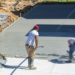 Unidentifiable hispanic men working on a new concrete driveway at a residential home