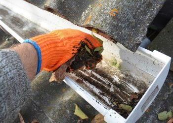 Rain Gutter Cleaning from Leaves in Autumn with hand. Roof Gutter Cleaning Tips. Clean Your Gutters Before They Clean Out Your Wallet. Step by Step. Gutter Cleaning.