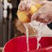 Woman wringing water out of a sponge into a bucket, detail