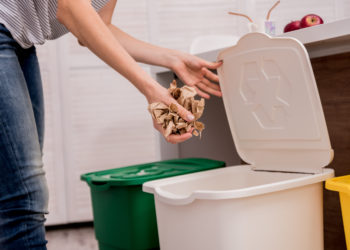 Young girl sorting garbage at the kitchen. Concept of recycling. Zero waste