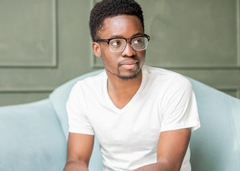 Portrait of a young afro ethnicity man sitting on the couch during the psychological session with psychologist in the office