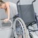 Woman moving from wheelchair to bathroom